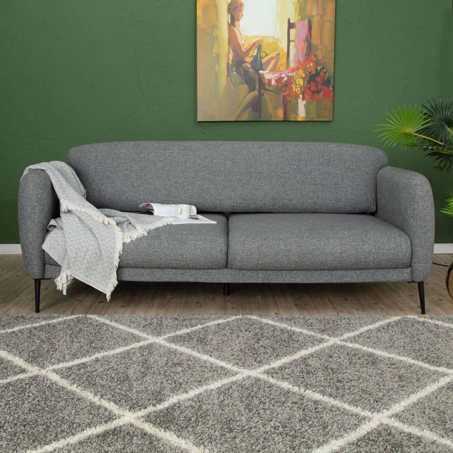 Gray textured fabric sofa with black legs placed on a moroccan grey shaggy rug 510 for cozy living spaces