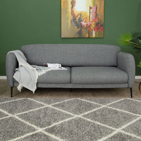 Gray textured fabric sofa with black legs placed on a moroccan grey shaggy rug 510 for cozy living spaces