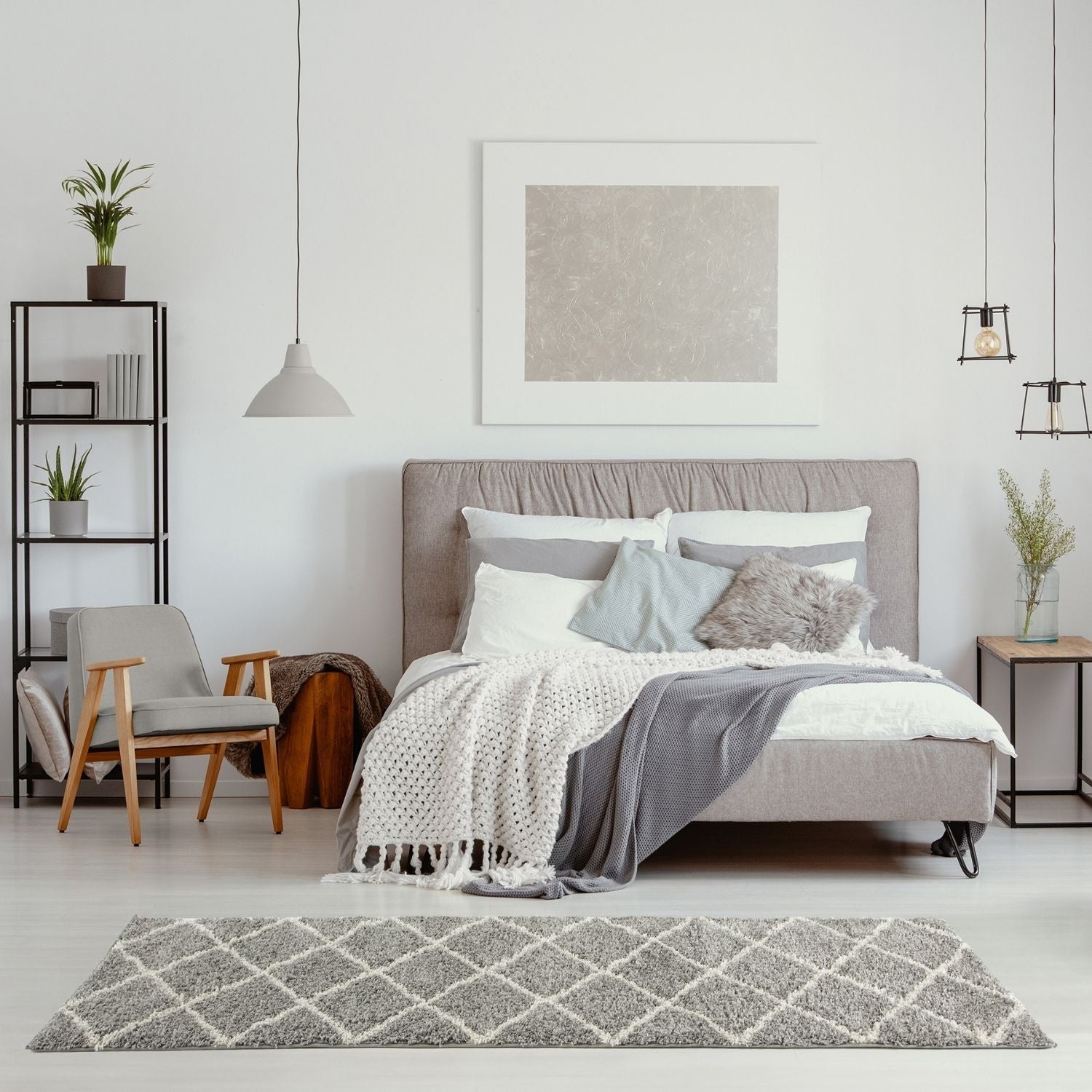 Gray upholstered bed with tufted headboard and layered bedding next to moroccan grey shaggy rug textured in gray
