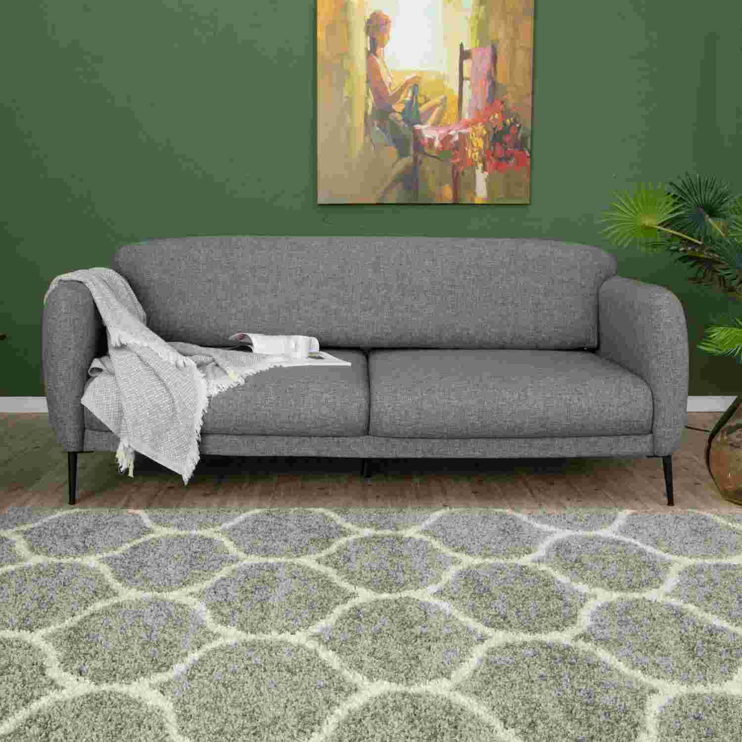 Gray textured fabric sofa with black legs and a light gray throw paired with a moroccan grey shaggy rug 610