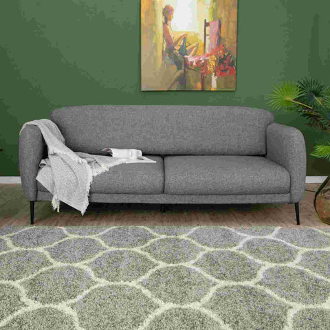 Gray textured fabric sofa with black legs and a light gray throw paired with a moroccan grey shaggy rug 610