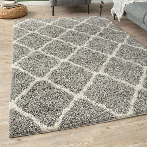 A moroccan grey shaggy area rug with a plush soft texture and geometric cream and gray pattern perfect for cozy spaces