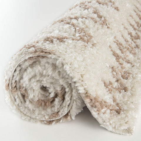 A plush moroccan ivory beige shaggy rug rolled up with soft white and beige stripes in fluffy textured material