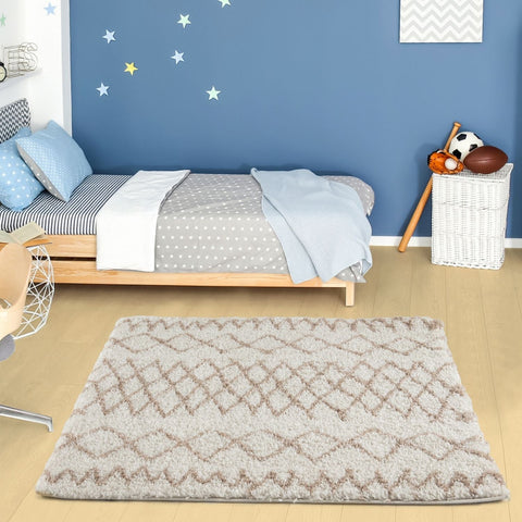 A soft plush moroccan ivory beige shaggy rug with a geometric diamond pattern in beige and gray tones