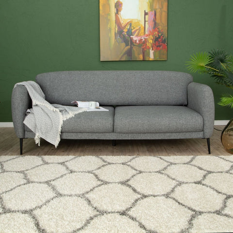 Gray textured fabric sofa with black legs shown on moroccan ivory shaggy rug with thick ivory shaggy pile