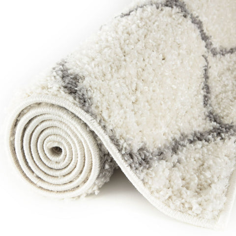 A moroccan ivory shaggy rug with soft cream color and subtle gray geometric patterns for cozy home decor