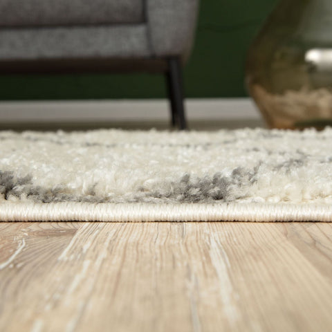 A plush moroccan ivory shaggy rug with a fluffy textured surface in cream and gray perfect for cozy spaces