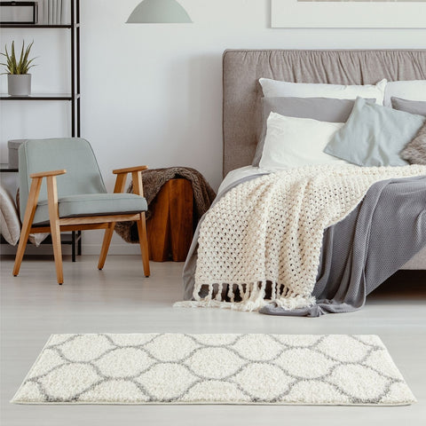 A plush moroccan ivory shaggy rug with white and gray geometric patterns and a soft, shaggy texture