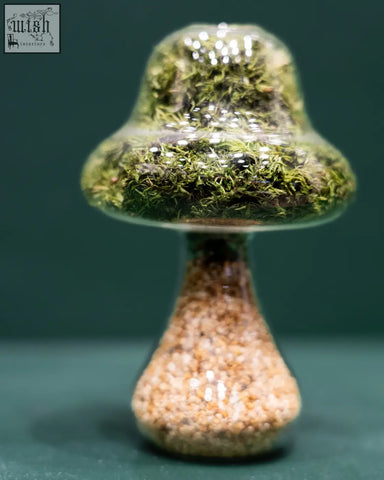 A tall moss mushroom terrarium with vibrant preserved moss and a natural stone base of multicolored pebbles