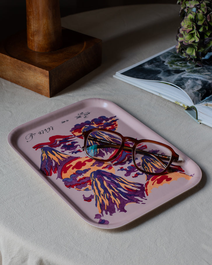 A rectangular wooden mount lucio tray with a pink base and vibrant purple and orange floral design