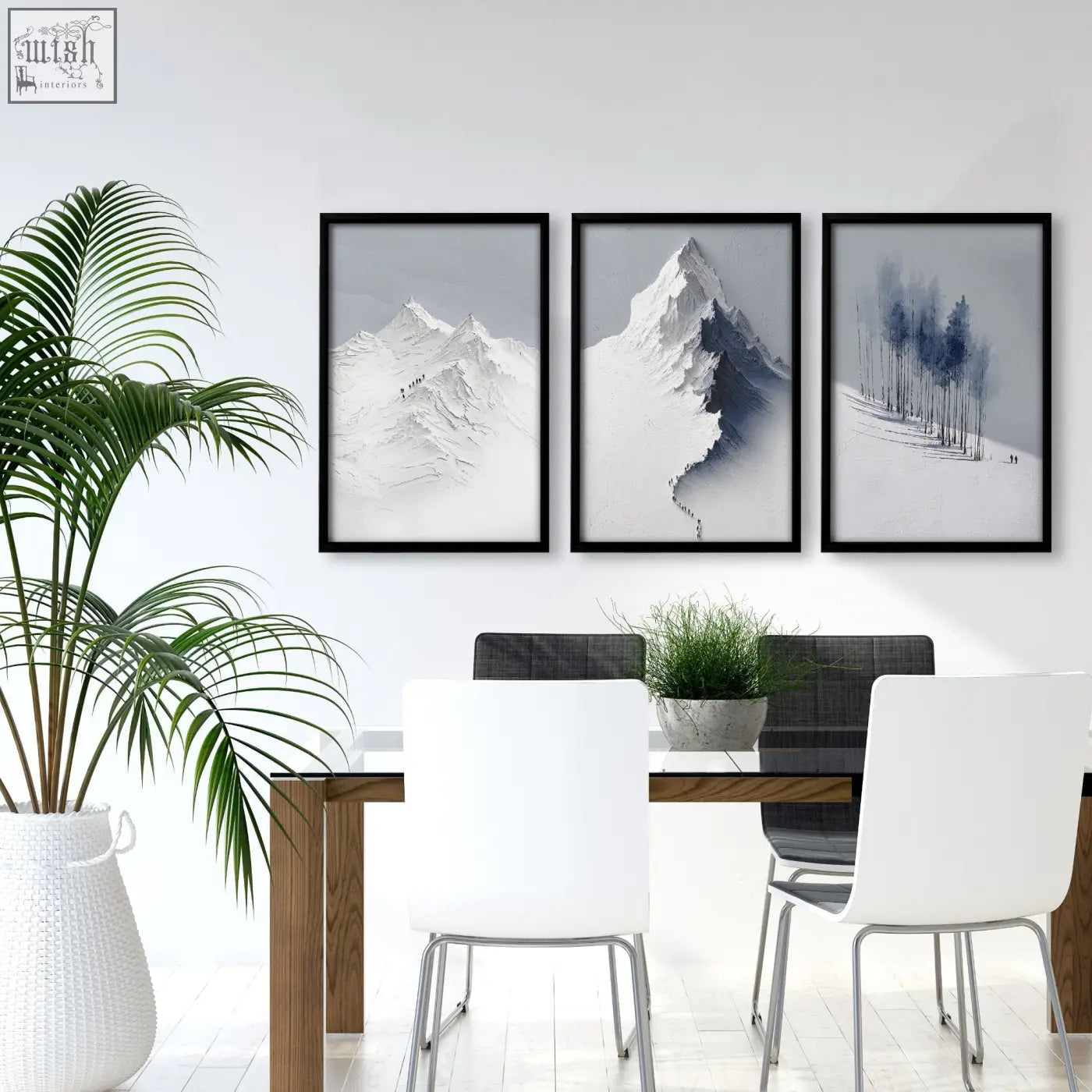 Three framed black and white mountain painting prints of snowy nordic peaks hang above a dining room table