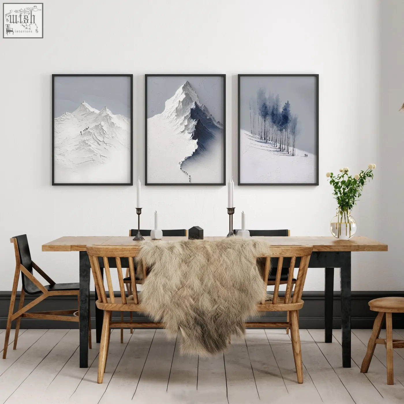 Three black-and-white mountain painting prints hang above a wooden dining room table for wall art decoration