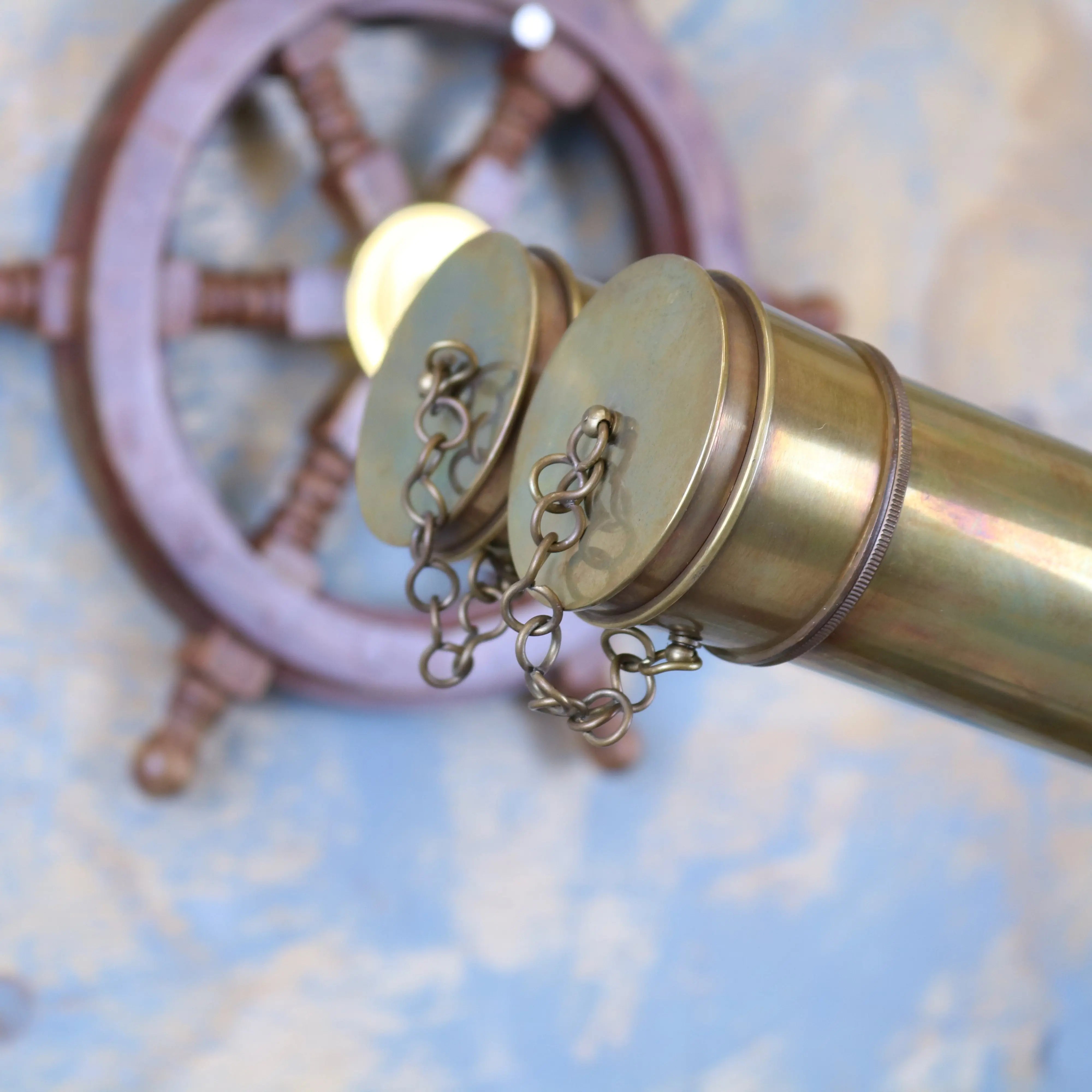 Brass mowai vintage binoculars with two circular caps and chain detail on a tripod for classic outdoor use