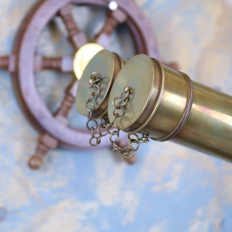 Brass mowai vintage binoculars with two circular caps and chain detail on a tripod for classic outdoor use