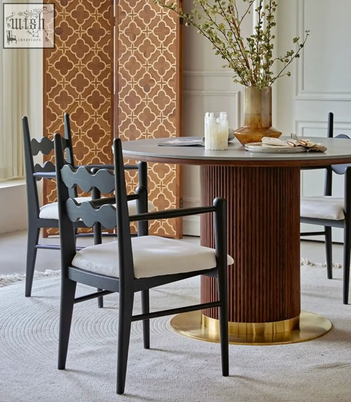 A sleek round dining table with dark wood ribbed pedestal base and gray tabletop for mucha dining chairs