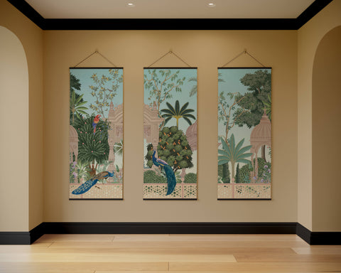 Three vertical mughal garden tapestries with intricate jungle scenes and peacocks hanging on a beige wall