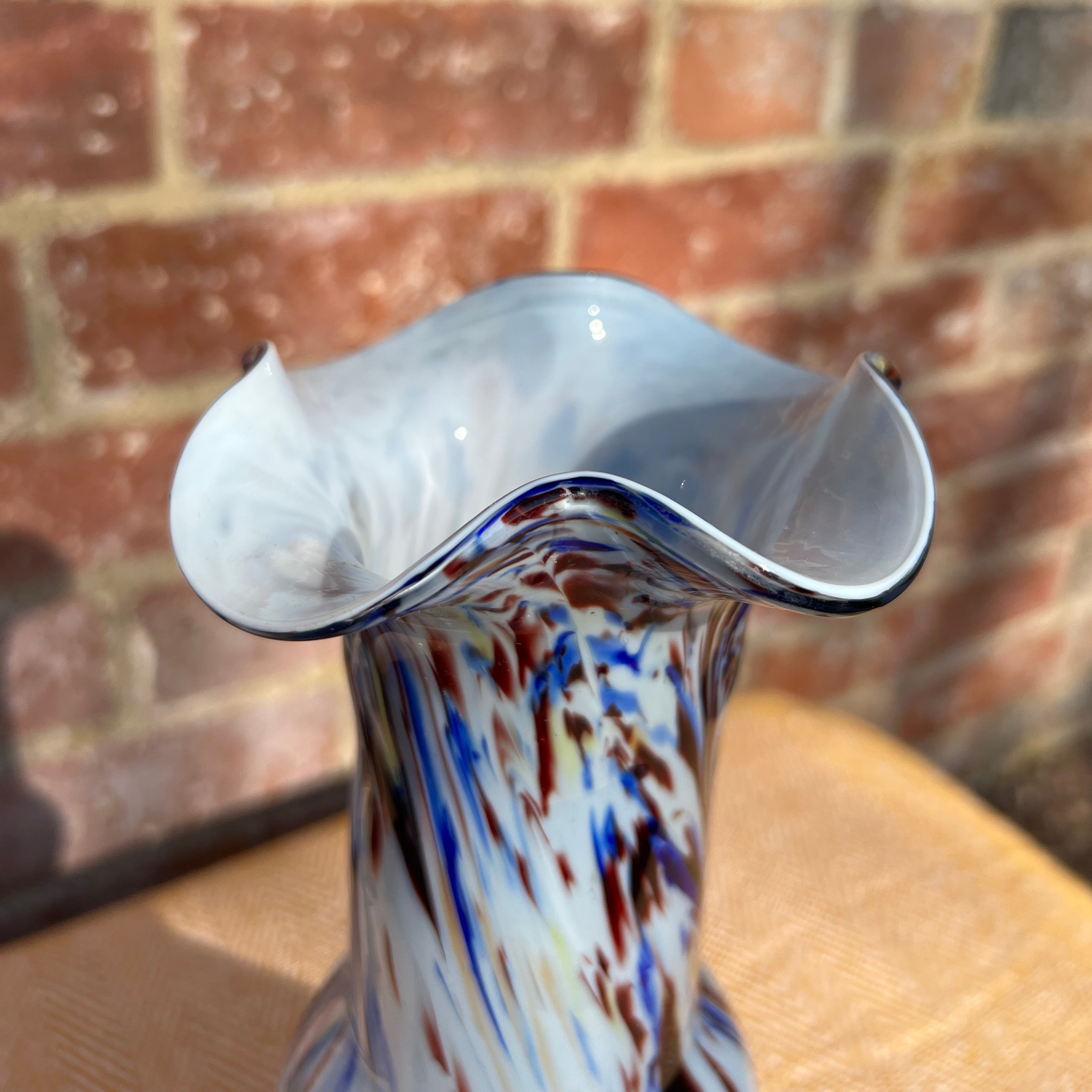 Murano tall glass vase with fluted rim featuring vibrant swirling blue red and white hand blown glass patterns