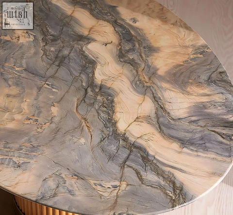 A murcell oval dining table with a round polished brazilian blue marble top featuring gray beige and gold veins