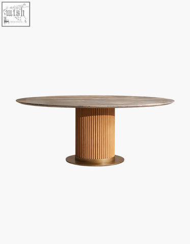 A sleek murcell oval dining table with brazilian blue marble top and fluted wooden pedestal base with brass rings