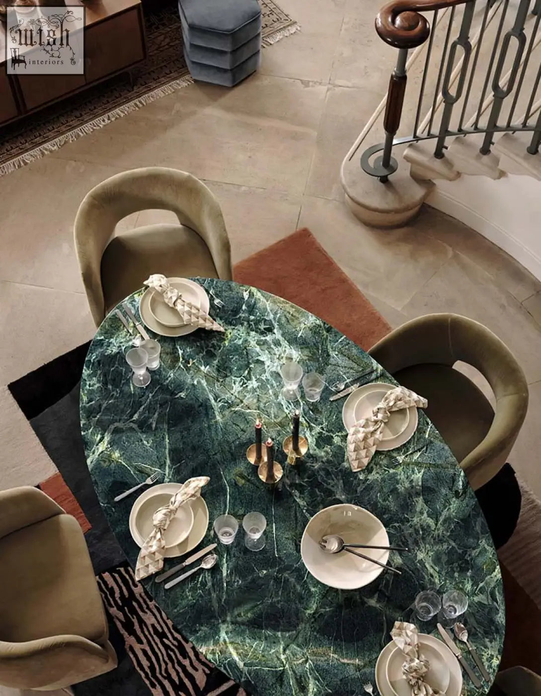 Emerald green marble murcell oval dining table with glossy veined surface and gold candle holders on top