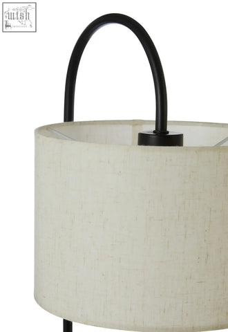 Beige linen curved table lamp with black metal handle and marble base featuring a white fabric shade