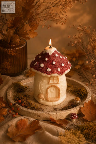 Red and white glittery mushroom house candle with natural soy wax featuring a lit wick and detailed arched doorway