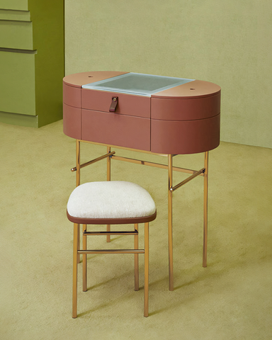 A sleek rose-pink muskoka dressing table set with glass top and gold-tone metal legs for stylish grooming