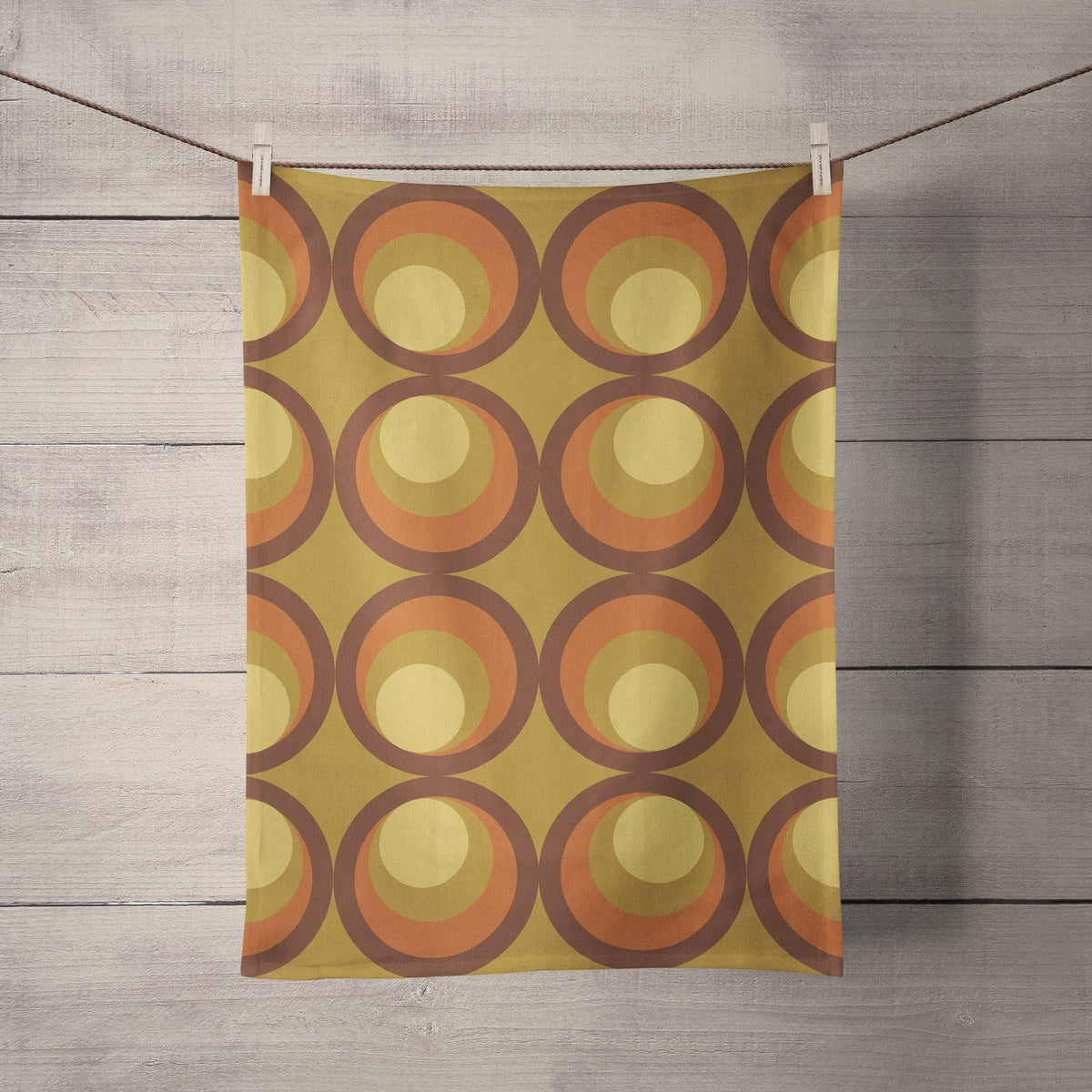 Mustard yellow tea towel with orange and brown retro circle pattern perfect for kitchen use