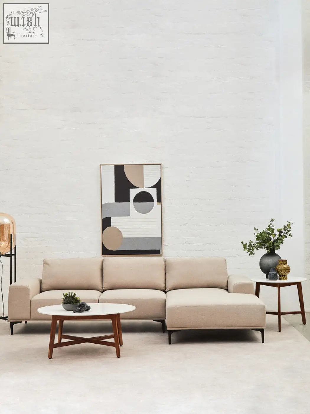 Beige sectional sofa with clean lines and wooden legs next to myan acacia wood and white marble round side table
