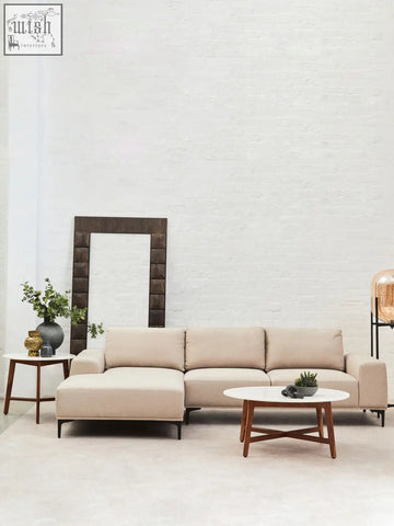 Beige leather sectional sofa with chaise lounge next to myan acacia wood white marble round side table