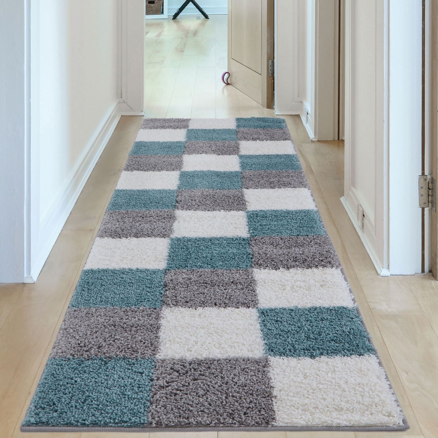 A plush shaggy area rug with a teal gray and duck egg blue checkerboard pattern perfect for cozy spaces