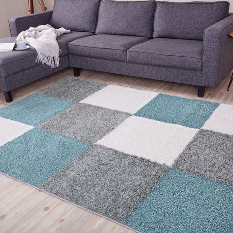A plush shaggy area rug with a duck egg blue patchwork design in teal gray and white perfect for cozy spaces