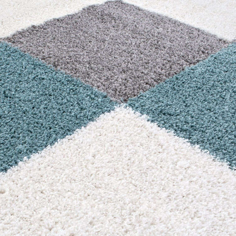 A plush shaggy rug with a geometric pattern in duck egg blue gray and white perfect for cozy spaces