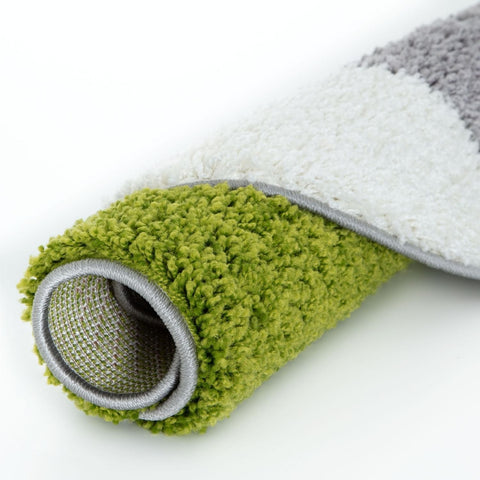 A plush rolled-up myshaggy geometric green rug with soft shaggy fibers gray border and vibrant green and white colors