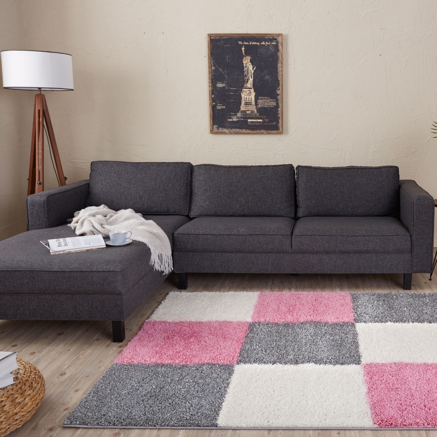 Dark gray fabric sectional sofa with left chaise lounge on myshaggy geometric pink rug in living room setting