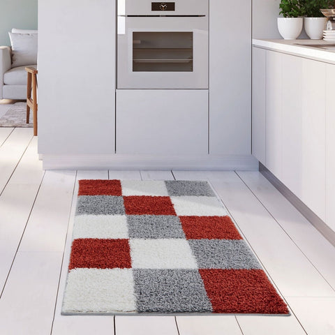 A plush rectangular kitchen rug with red white and gray geometric squares from myshaggy geometric terra collection
