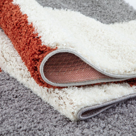 A plush shaggy area rug with a modern white terracotta orange and gray geometric pattern myshaggy geometric terra