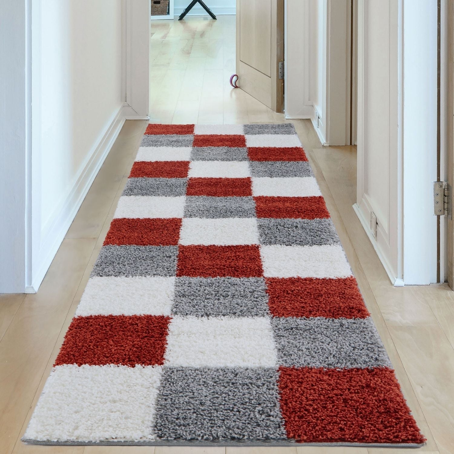 A plush shaggy runner rug from myshaggy geometric terra with bold red white and gray checkered pattern