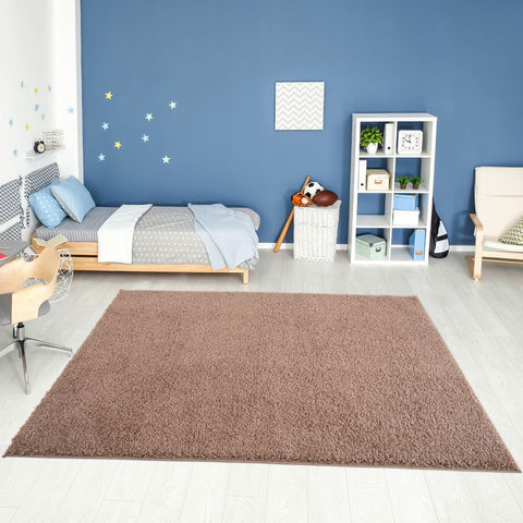 A plush rectangular solid beige rug with soft shaggy texture from myshaggy solid beige on light wooden floor