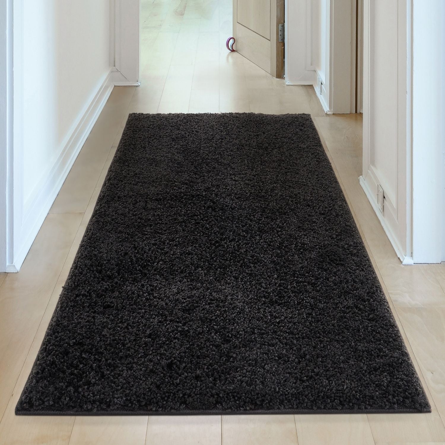 Black shaggy area rug with a plush textured surface from myshaggy solid black solid black rug collection