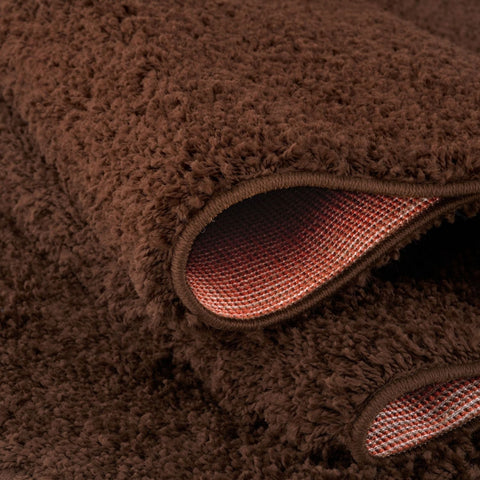 Brown rug showing the woven backing of the myshaggy solid brown rug with soft fluffy plush texture