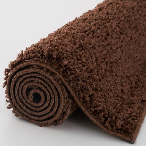 A plush myshaggy solid brown rug with soft shaggy texture and neatly stitched edges perfect as a brown rug bath mat