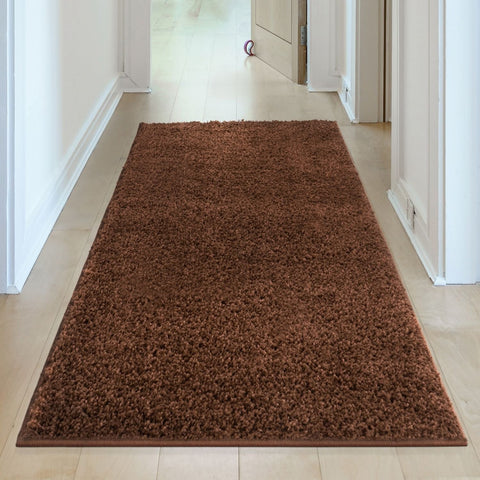 A plush myshaggy solid brown rug with soft shaggy texture lies centered in the hallway as a brown rug