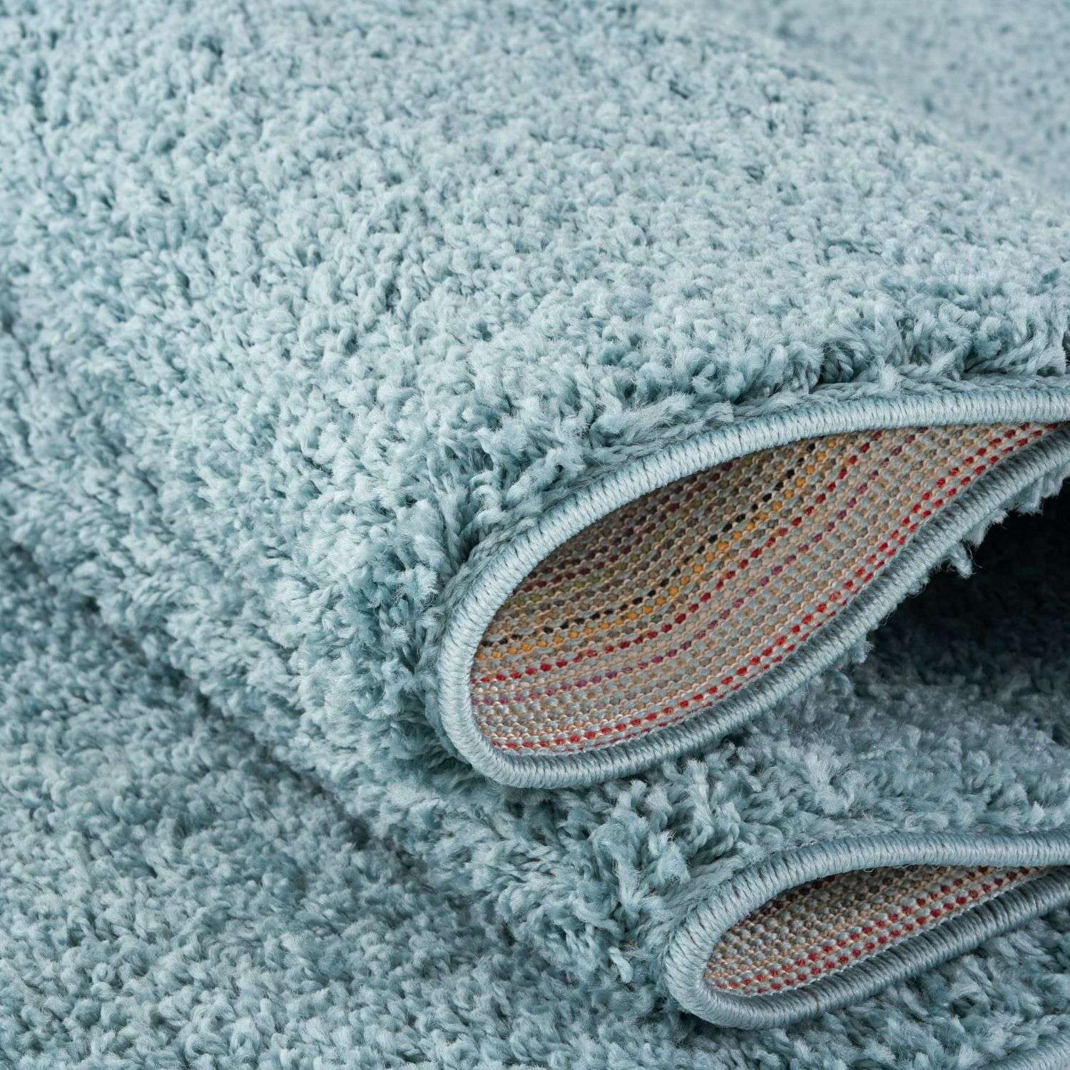 A plush light blue shaggy bath mat with a soft textured surface and duck egg blue color perfect for bathroom use