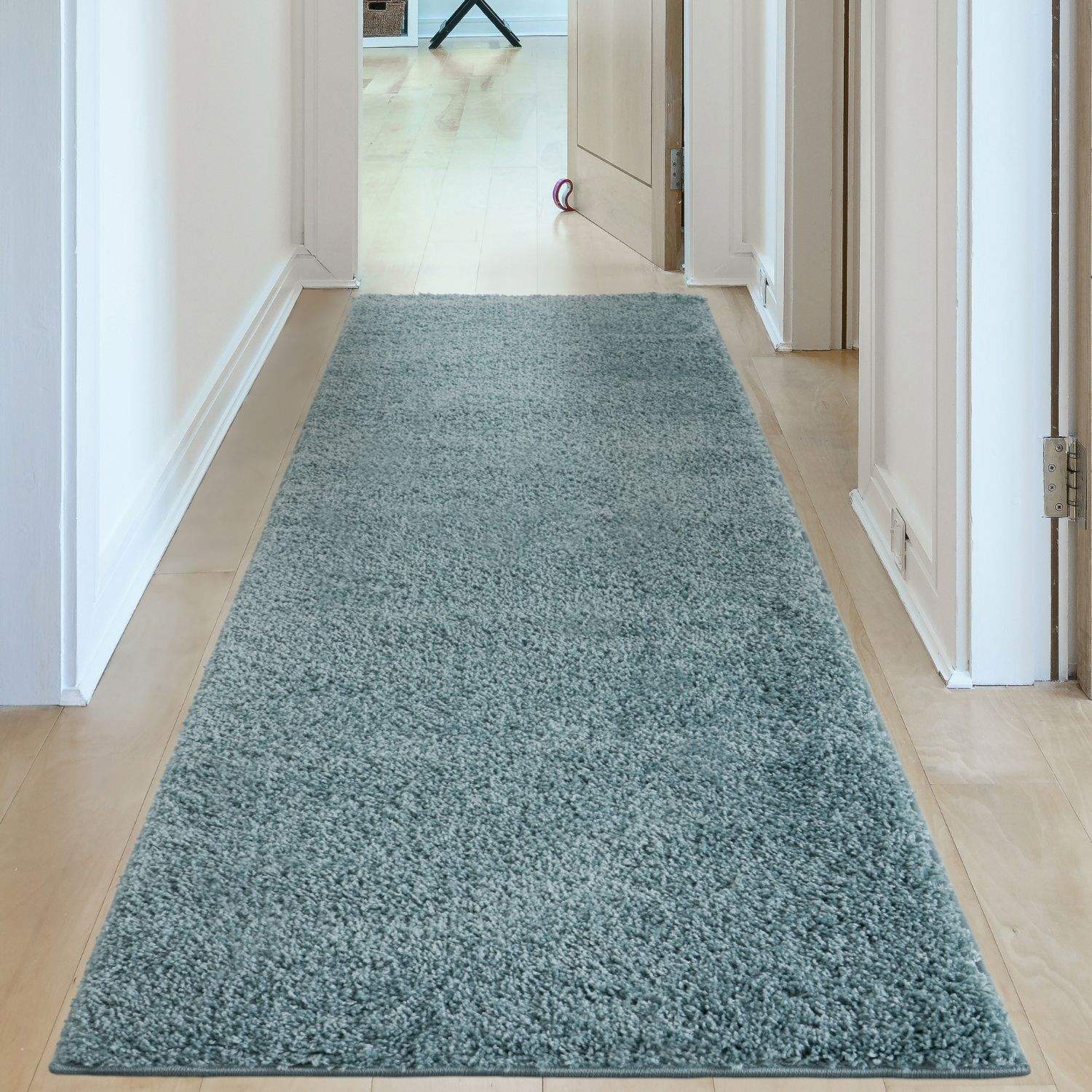 A plush light blue shaggy runner rug in duck egg blue perfect for brightening up any hallway floor