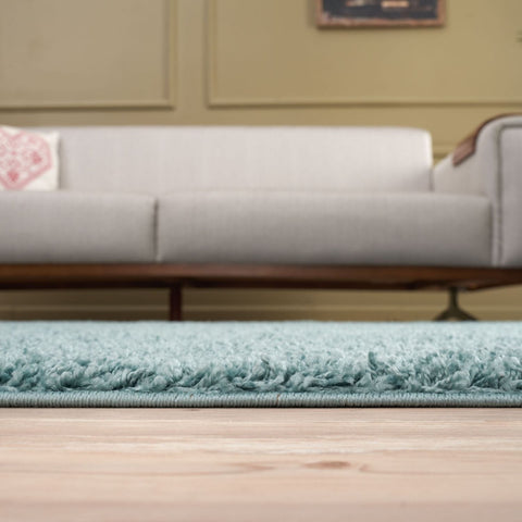 A plush light teal duck egg blue shag rug with a soft textured surface and neatly finished edges perfect for cozy spaces