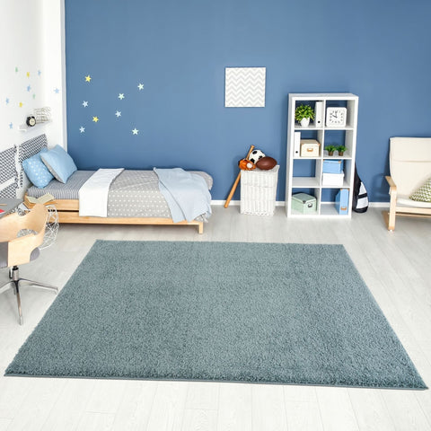 A plush rectangular duck egg blue rug with soft shaggy texture on a light wood floor perfect for cozy spaces