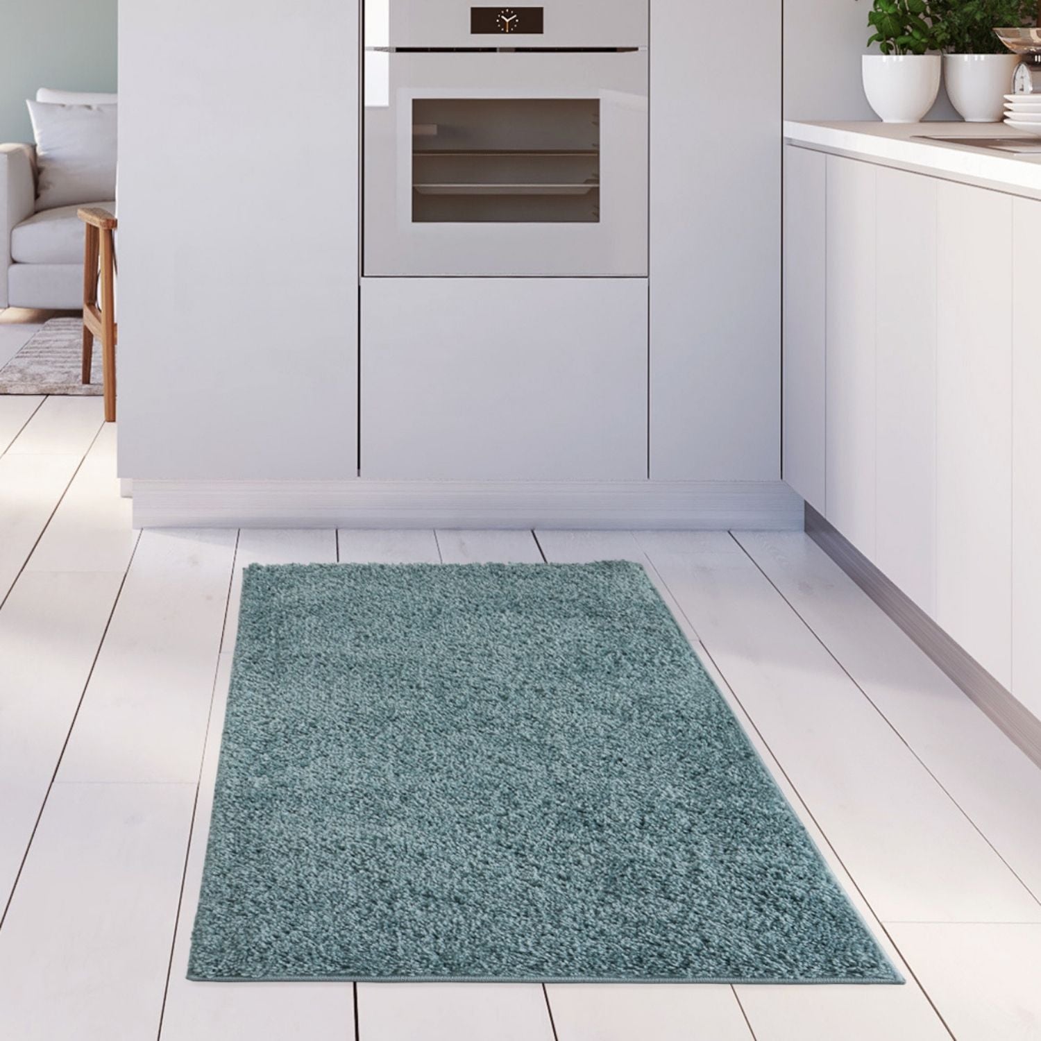 A plush shaggy duck egg blue rug on white wooden floor in front of modern kitchen cabinets perfect for cozy spaces