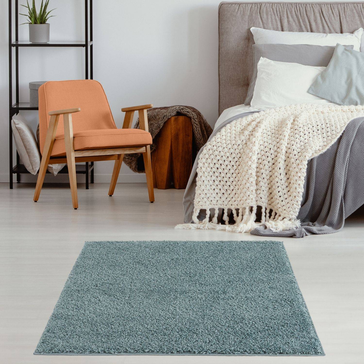 A rectangular teal shaggy rug with plush texture in duck egg blue sits centered in the room foreground