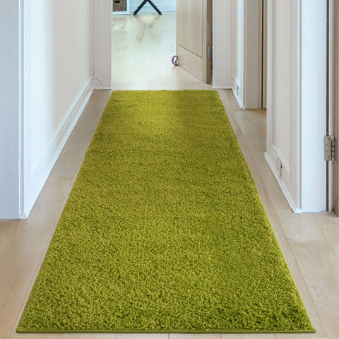 A vibrant lime green myshaggy solid green rug with plush 30mm pile laid on a light wood floor hallway